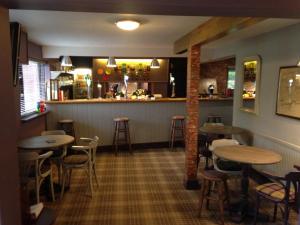 a restaurant with tables and chairs and a bar at Yorkway Motel in Pocklington