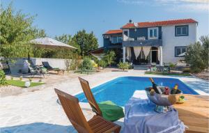 a pool with a table and chairs and a house at Beautiful Home In Skradin-dubravice With 4 Bedrooms, Wifi And Outdoor Swimming Pool in Čulišić