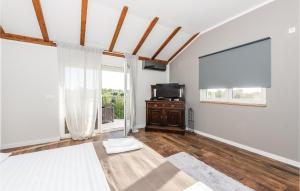 uma sala de estar com televisão e uma grande janela em Stunning Home In Skradin-dubravice With House A Panoramic View em Čulišić