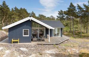 Vester SømarkenにあるBeautiful Home In Nex With 3 Bedrooms, Sauna And Wifiの青い小さな家 ポーチとデッキ付