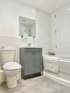 a bathroom with a toilet and a sink and a tub at 1 Merchants Gate - 2 bedroom, city apartment with private parking in York