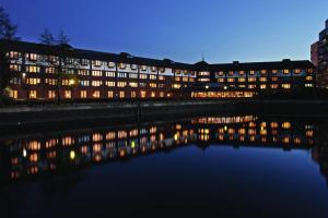ein großes Gebäude mit Lichtern im Wasser bei Nacht in der Unterkunft Copthorne Hotel Manchester Salford Quays in Manchester