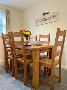 a wooden table with chairs and a vase of flowers on it at 1 Merchants Gate - 2 bedroom, city apartment with private parking in York +17 photos
