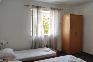 een slaapkamer met 2 bedden en een raam bij Apartment in nature in Bijela