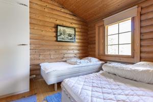 zwei Betten in einem Zimmer mit Holzwänden in der Unterkunft Villa Blue beach / Siniranta in Parkano