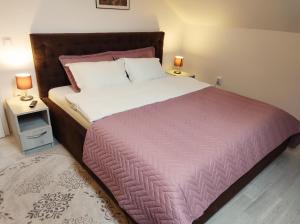 a bedroom with a large bed with a purple blanket at Simona Apartament Palas Mall in Iaşi