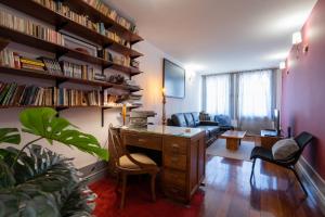 ein Wohnzimmer mit einem Schreibtisch und einem Sofa in der Unterkunft Casa da Hera - The Ivy House in Porto
