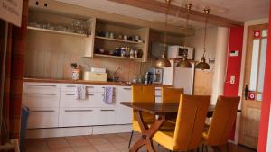 een keuken met een houten tafel en gele stoelen bij Appartement de Voshaar in Enschede