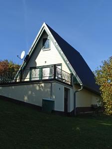 a house with a balcony on the side of it at Bungalow Sud-Harz Bleicherode - boven in Bleicherode