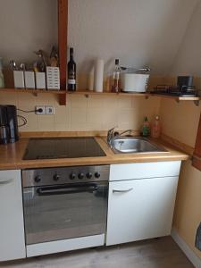 a kitchen with a sink and a stove at Bungalow Sud-Harz Bleicherode - boven in Bleicherode