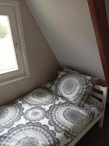 a bed with two pillows on it in a room at Bungalow Sud-Harz Bleicherode - boven in Bleicherode