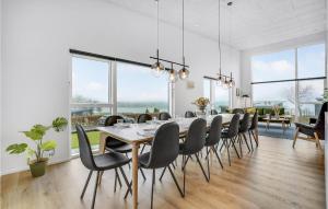 comedor con mesa, sillas y ventanas grandes en Lovely Home In Lgstrup With Wifi en Løgstrup