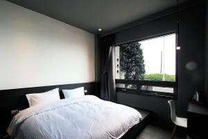 ein Schlafzimmer mit einem weißen Bett und einem Fenster in der Unterkunft 窗外的海 - 海洋公園旁 in Yanliau
