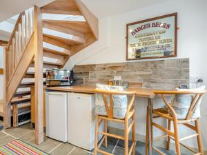 a kitchen with a table and chairs and a staircase at The Studio in Woolland