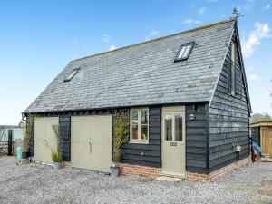 a small black house with two garage at The Studio in Woolland