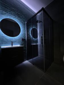 a dark bathroom with a shower and a sink at Comfort Hostel Klaipeda in Klaipėda