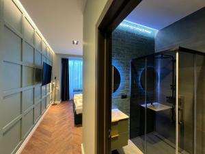 a bathroom with a shower and a sink and a mirror at Comfort Hostel Klaipeda in Klaipėda