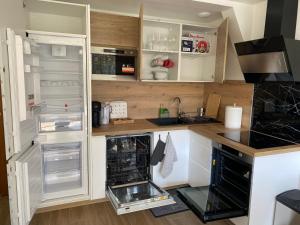 a kitchen with white cabinets and an open refrigerator at Amazing flat, Paris suburb, near Versailles ,Orly in Orsay +13 photos