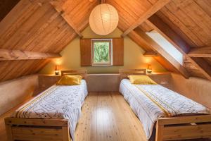 2 łóżka w pokoju na poddaszu z drewnianymi sufitami w obiekcie MAISON YUKTI - Magnifique maison de charme proche plage w mieście Lampaul-Ploudalmézeau