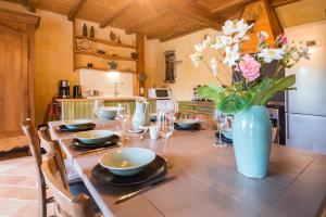 stół z wazonem kwiatów w kuchni w obiekcie MAISON YUKTI - Magnifique maison de charme proche plage w mieście Lampaul-Ploudalmézeau +37 zdjęć