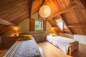 dwa łóżka w pokoju z drewnianym sufitem w obiekcie MAISON YUKTI - Magnifique maison de charme proche plage w mieście Lampaul-Ploudalmézeau