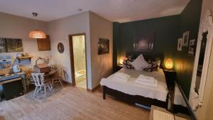 a bedroom with a bed and a kitchen and a table at The Orchards Guest Suite in Willand