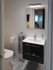 a bathroom with a sink and a toilet and a mirror at The Tides in Cleethorpes