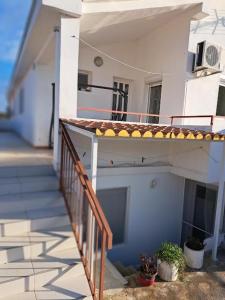 een gebouw met een veranda en een balkon met planten bij Apartments Jele II in Sveti Petar