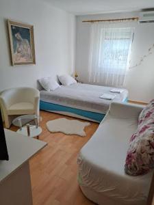 een kleine slaapkamer met een bed en een stoel bij Apartments Jele II in Sveti Petar
