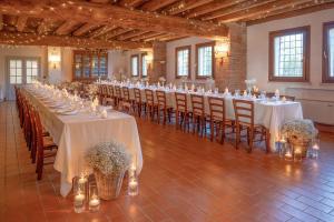 una fila de mesas con manteles y sillas blancas en Agriturismo Tenuta La Pila, en Villa Bartolomea