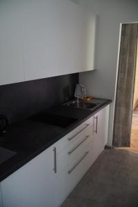 a kitchen with white cabinets and a sink at Pension Hartmann in Sankt Kanzian