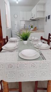 a table with white plates and wine glasses on it at Chicama D'Amore - Family Place & Wave Paradise - Parking & kidszone - on Puerto Chicama in Puerto Chicama