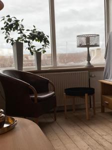 un soggiorno con sedia, tavolo e lampada di 200 m til havet - fri adgang til svømmehal a Thyborøn