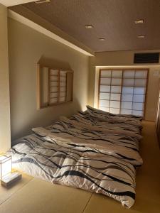 Ce lit se trouve dans un dortoir doté d'une fenêtre. dans l'établissement Yanaka Kotobuki Sou, à Tokyo