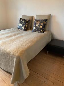 un letto con due cuscini sopra in una stanza di 200 m til havet - fri adgang til svømmehal a Thyborøn