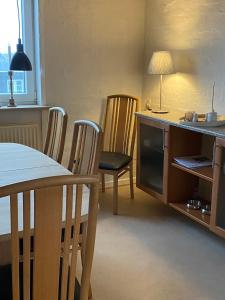 - une salle à manger avec une table, des chaises, une table et des chaises dans l'établissement 200 m til havet - fri adgang til svømmehal, à Thyborøn
