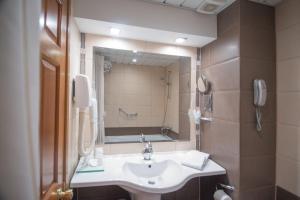 a bathroom with a sink and a mirror at Hotel Burgas in Burgas City