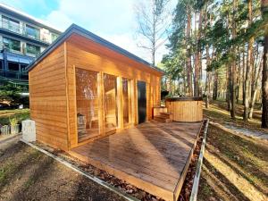 een klein houten huis met een groot terras bij Apartament nad Zalewem in Serock