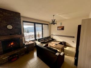 a living room with a couch and a fireplace at Rodopski Ailyak in Dospat