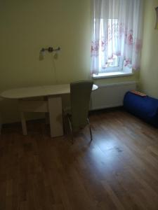a room with a table and a chair and a window at Апартаменти Volodymyra Velykoho in Ivano-Frankivsʼk
