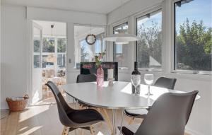 jadalnia ze stołem, krzesłami i oknami w obiekcie Awesome Home In Gudhjem With Wifi w mieście Gudhjem