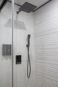 a shower in a bathroom with a phone on the wall at Villa Infante in Huelva