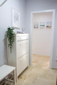 a white room with a white dresser and a door at Villa Infante in Huelva