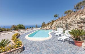 a swimming pool with chairs and the ocean in the background at 3 Bedroom Lovely Home In Agropoli Sa in Ogliastro Cilento +18 photos