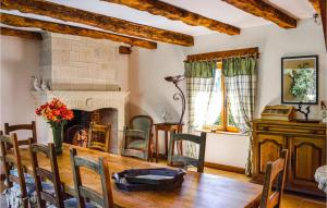 ein Esszimmer mit einem Tisch und einem Kamin in der Unterkunft Beautiful Home In La Cassagne With Kitchen in Ladoux