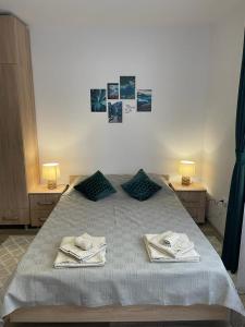 a bedroom with a bed with towels on it at Island apartman in Odorheiu Secuiesc