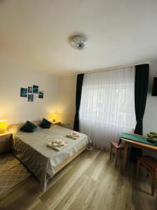 - une chambre avec un grand lit et une table dans l'établissement Island apartman, à Odorheiu Secuiesc