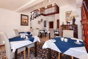 Hermanus的住宿－Villa Venusta Luxury Guesthouse - Solar Power，一间设有蓝色桌椅的餐厅,以及楼梯