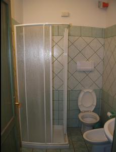 een badkamer met een douche, een toilet en een wastafel bij Casa Luminosa in Cala Liberotto