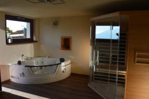 Das Bad ist mit einer Badewanne und einer Glasdusche ausgestattet. in der Unterkunft Chalet Buonriposo in Cremia